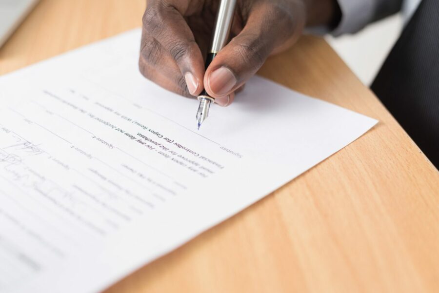 Body-shop-owner-with-contract-to-not-install-ADAS-1200×801 person signing contract