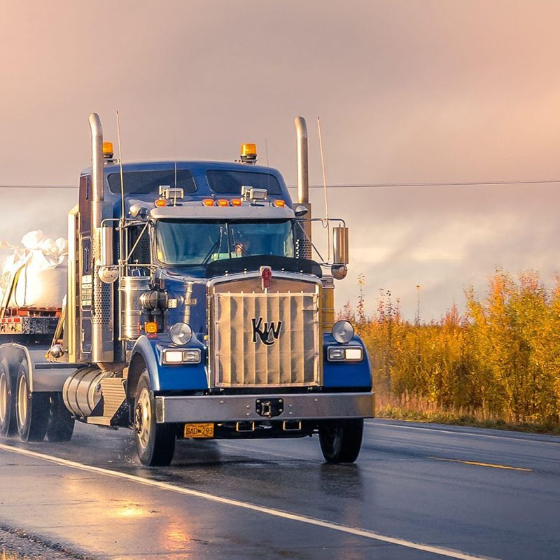 semi truck driving through the sunset