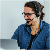 Technician Repair Hotline-100 A man working on his laptop with headphones