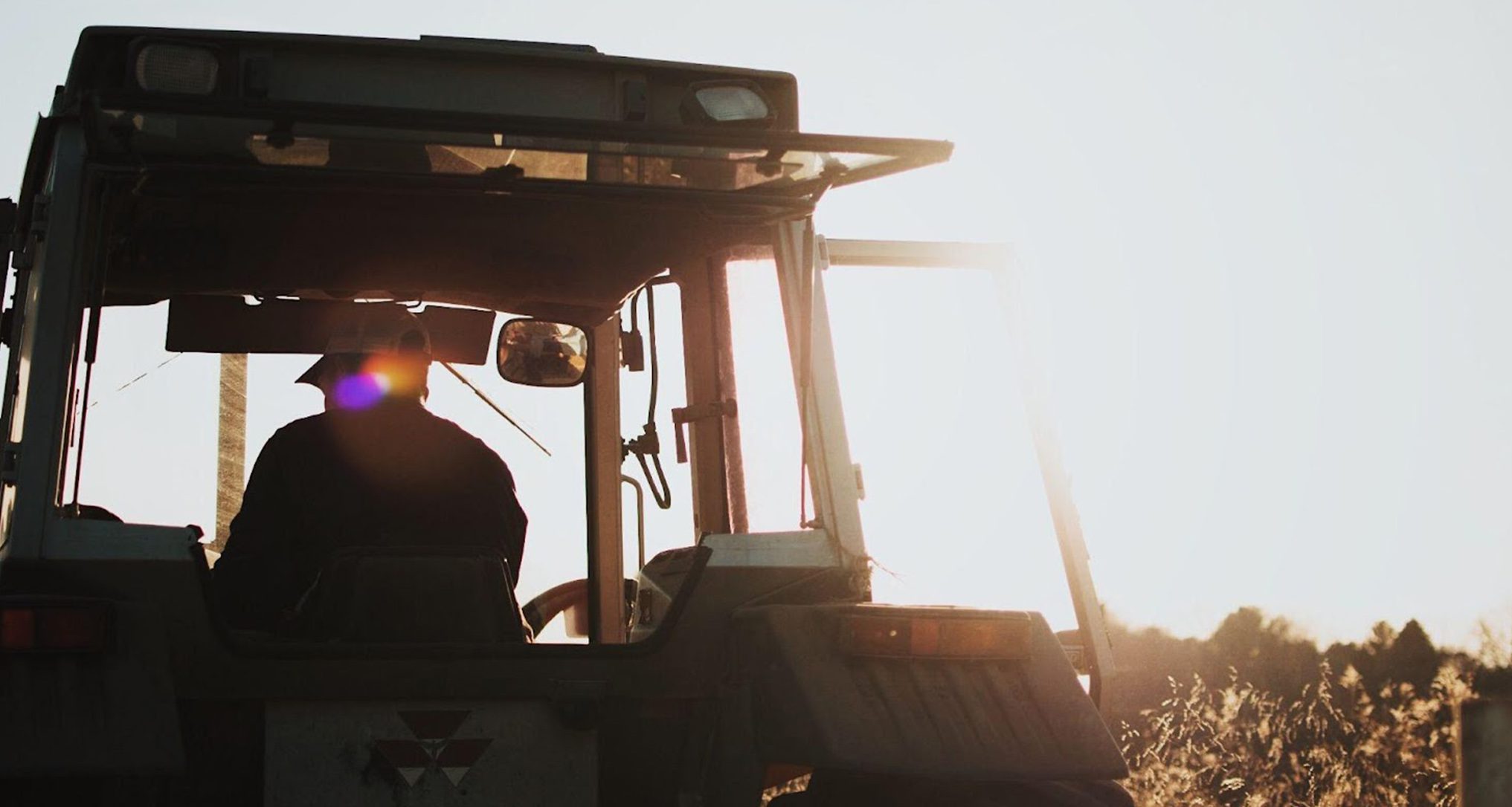 tractor riding into the sunset